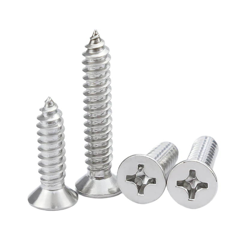 Close-up of stainless steel Phillips countersunk self-tapping wood screws, two standing upright and two lying to show drive heads