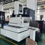 Used BQ800 CNC wire cut EDM machine positioned on a factory floor, with its attached operator control stand and monitor visible