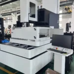 Front-right angle view of a used BQ800 CNC wire cut EDM machine in an industrial shop, with its work enclosure door open