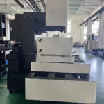 Side view of a used BQ800 CNC wire cut EDM machine showing its vertical wire head and stacked base on a factory floor